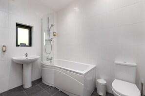 Une salle de bain moderne avec une baignoire, un lavabo et des toilettes.