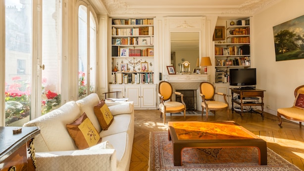 Ein helles Wohnzimmer mit Kamin, Bücherregalen und einem Fernseher.