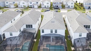 A residential area with multiple houses, each featuring a sloped roof and a covered outdoor swimming pool. - 4764- Great Family Home near Disney, Pool & Spa - Storey Lake Resort (Kissimmee)