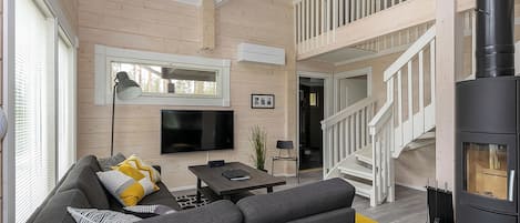Een moderne woonkamer met een bank, televisie en open haard.