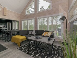 A modern interior with a sofa, coffee table, and dining area.