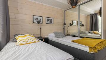 Ein Schlafzimmer mit zwei Betten, einem großen Spiegel und zwei Wandlampen.