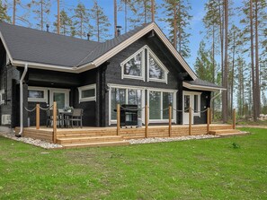 A cabin with a deck, large windows, and a forest backdrop. - Vacation home Hiili by Interhome (Sonkajärvi)