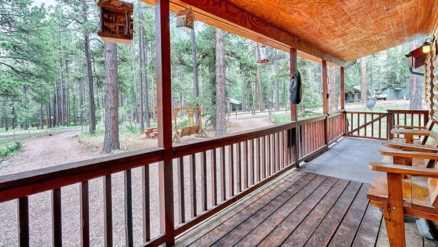 A wooden deck with a view of a forest.