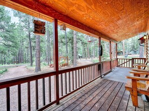 Overlooking a serene forest, this cabin's deck offers a tranquil retreat.