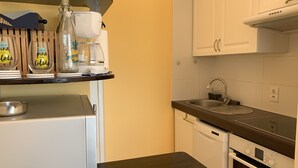 A compact kitchen with white cabinets, a stainless steel sink, and a built-in dishwasher. - Duplex T2 Arcachon: Terrasse, Wifi, 100m Plage, Proche Centre (Arcachon)