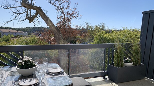 An outdoor dining area with a table set for two, surrounded by potted plants and a view of a residential area. - Duplex T2 Arcachon: Terrasse, Wifi, 100m Plage, Proche Centre (Arcachon)