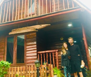 Experience the rustic charm of this cabin, featuring a spacious porch with a large window offering views of the surrounding area.