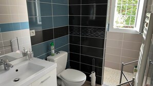 A modern bathroom with a white sink, toilet, and vanity.