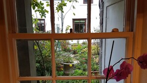 A window with a view of a garden and a building across the street. - The Wee Nook, Birnam & Dunkeld (Birnam)
