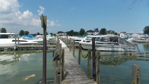 A wooden pier leading to a marina with several boats docked.