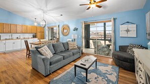 A spacious living area with a gray sofa, a coffee table, and a ceiling fan.