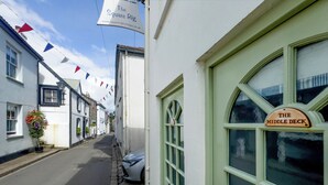 Una calle estrecha con edificios, incluyendo un pub llamado 'The Middle Deck'.