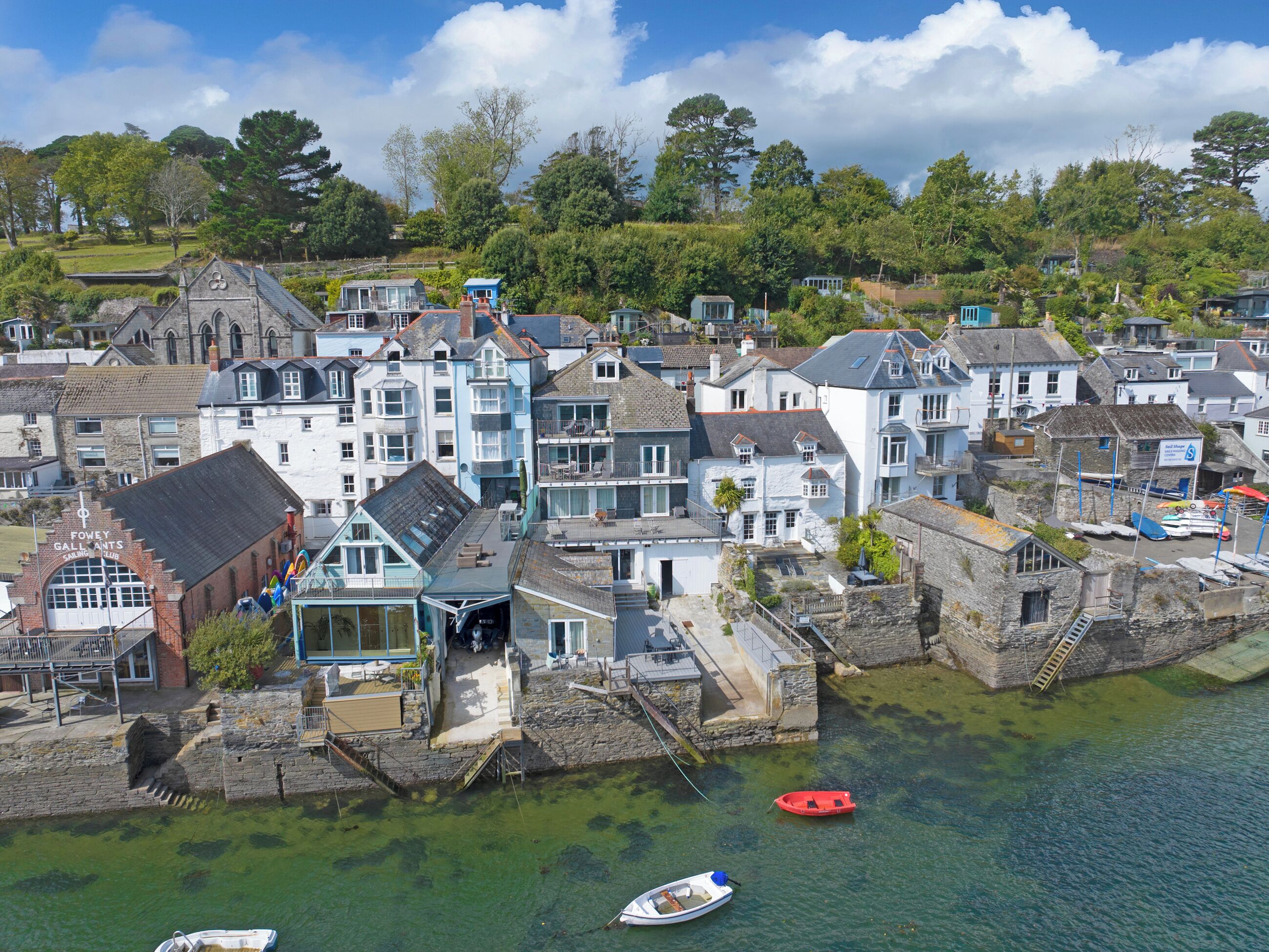 A coastal town with a mix of residential and commercial buildings, including a prominent building labeled 'Fowey Gallants'.