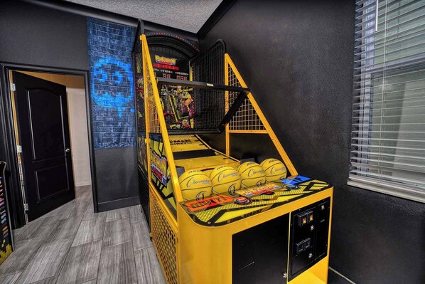 Una cama litera con estructura amarilla y un pequeño escritorio con una computadora y libros.