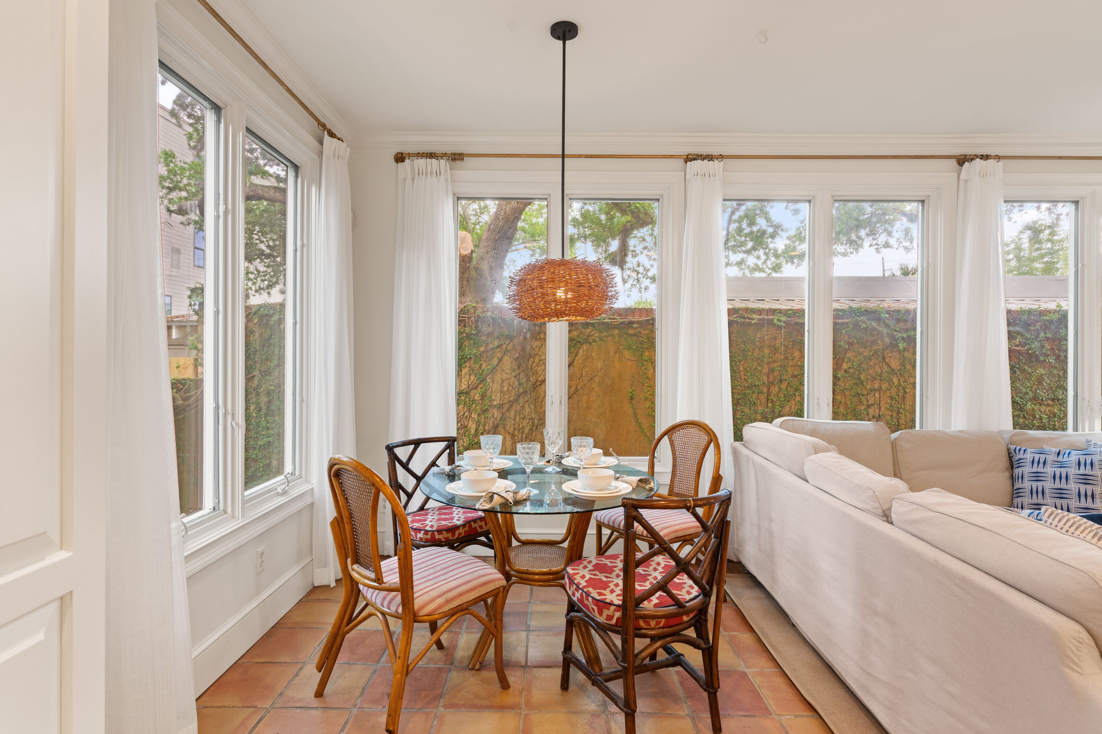 A dining area with a round table, chairs, and a hanging light fixture.