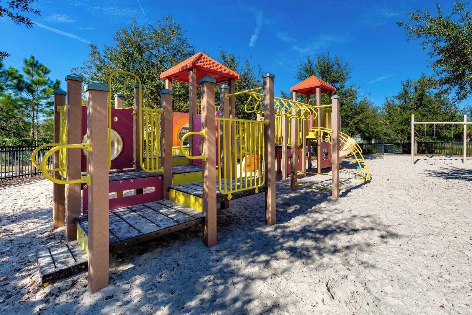 Un parque infantil con tobogán, estructuras para escalar y una zona cubierta.