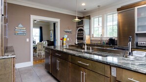 Una cocina moderna con armarios de madera oscura, encimera de granito y electrodomésticos de acero inoxidable.