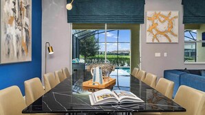 Una sala de reuniones moderna con una mesa de mármol negro, sillas color beige y un amplio ventanal con vistas a un paisaje verde.