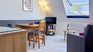 A modern room with a wooden dining table, a sofa, a TV, and a skylight. - Gollwitzer Park (Insel Poel) by Interhome (Gollwitz (Insel Poel))