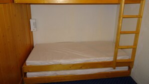 A bunk bed with a ladder, a control panel, and a blue polka dot carpet.
