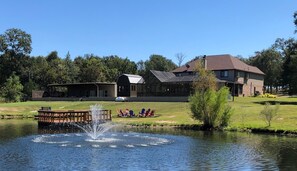 A lakeside property with a house, a dock, and a fountain.