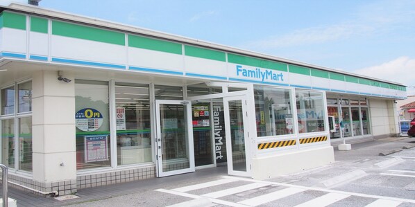 A FamilyMart store with a clear entrance, visible signage, and a tiled pavement outside. - Lagoon Palace (Kadena)