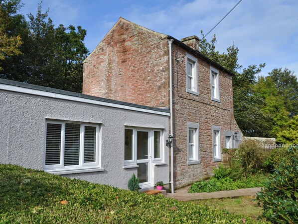 A two-story building with a stone facade and white-framed windows. - 2 bedroom accommodation in Waverton, near Wigton (Waverton, near Wigton)