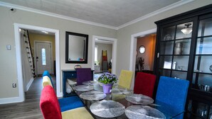 A dining area with a glass table, colorful chairs, and a black cabinet with glass doors. - Excellent Location, Family & Pet Friendly, Walk to Main St, Close to everything (Bethlehem)