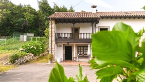Un edificio de dos pisos con un balcón, un muro de piedra y un cartel que dice "SASA PAULA".