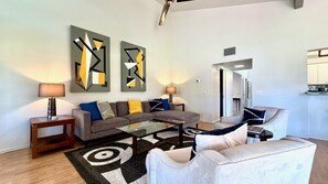 Ein modernes Wohnzimmer mit einer Couch, einem Couchtisch und Kunstwerken an der Wand.
