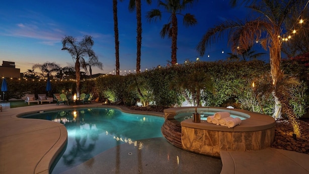 A swimming pool with a hot tub, surrounded by palm trees and a hedge. - Bliss: Pool, Spa, Pool Table, Ping Pong, Fire Pit! (Indio)
