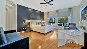 A modern bedroom with a large bed, a ceiling fan, and a view of the outdoors. - Bliss: Pool, Spa, Pool Table, Ping Pong, Fire Pit! (Indio)