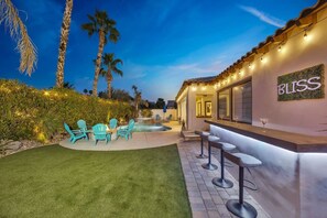 A poolside area with outdoor seating and a bar. - Bliss: Pool, Spa, Pool Table, Ping Pong, Fire Pit! (Indio)