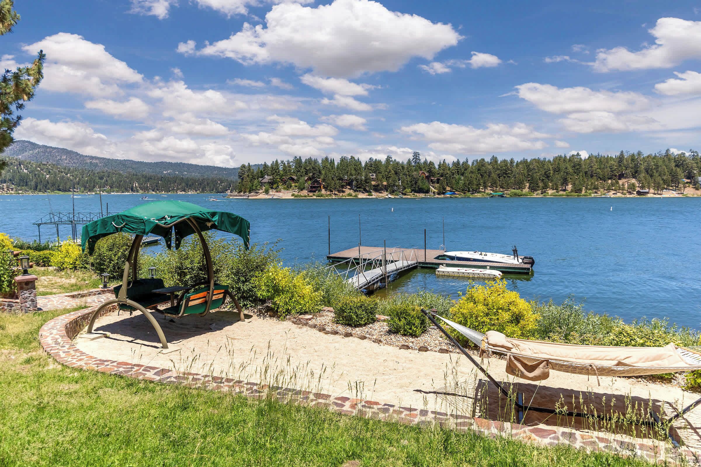 Une terrasse au bord du lac, agrémentée d’un belvédère, d’un hamac et d’un quai avec des bateaux.