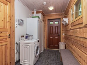 Une petite buanderie équipée d’un lave-linge, d’un sèche-linge et d’un petit évier.
