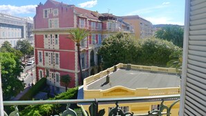 Um edifício com várias andares, varandas e vista para a rua.
