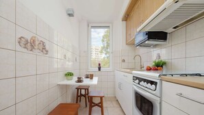A compact kitchen with a window, a stove, and a small dining area.