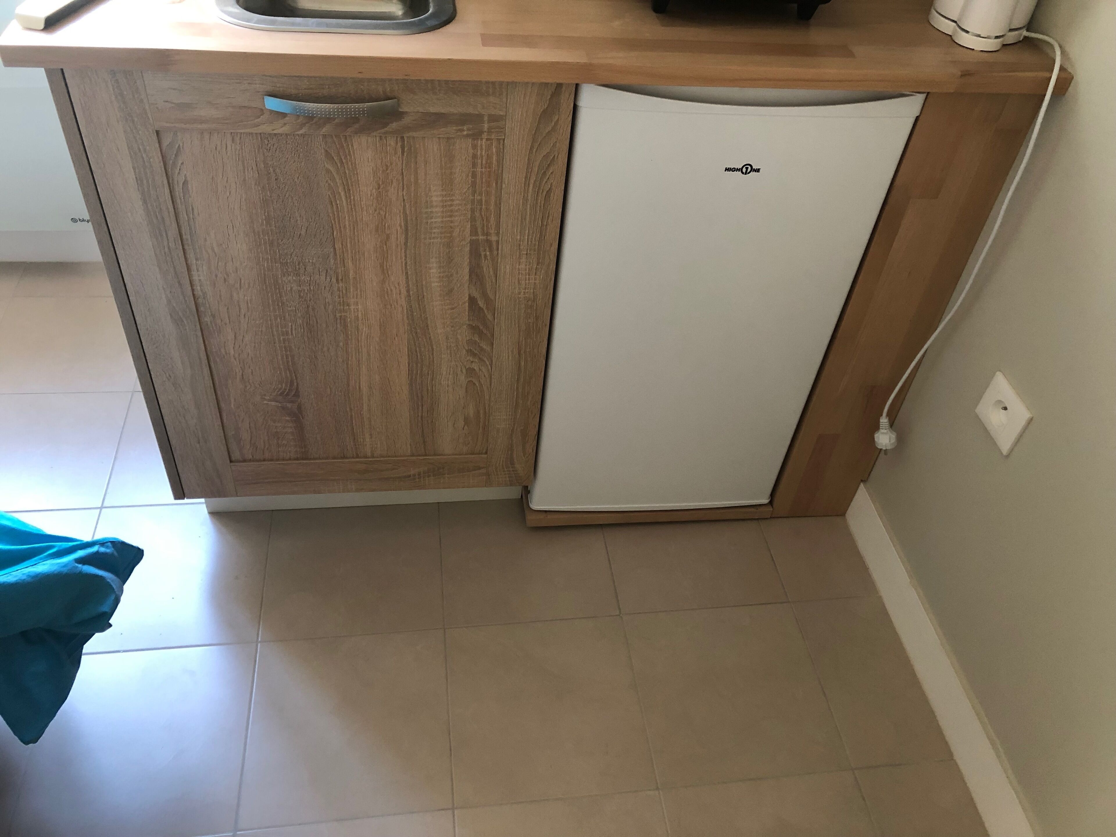 A kitchen with a wooden cabinet and a white refrigerator.