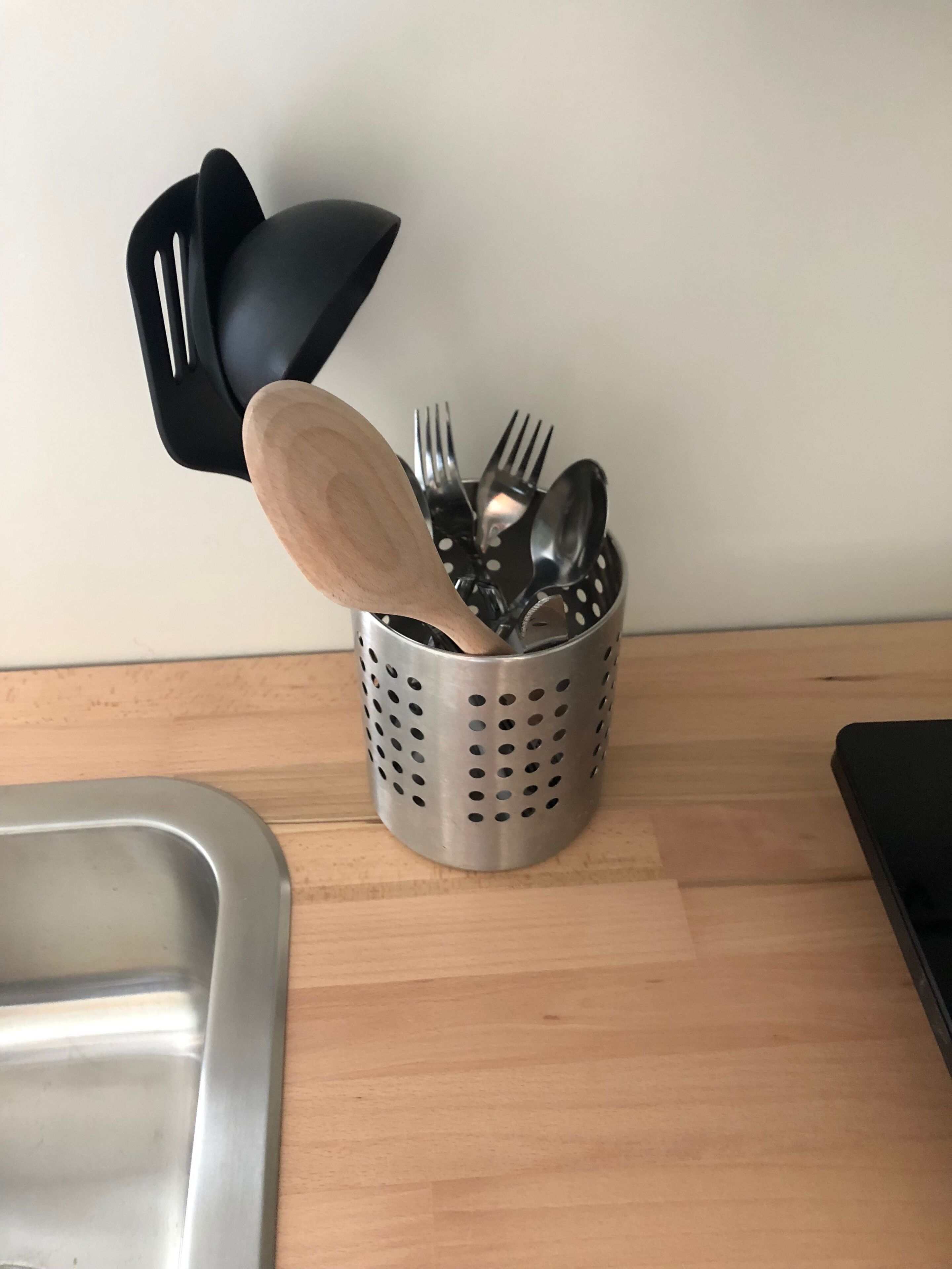 Een roestvrijstalen spoelbak met een houten snijplank ertegenaan.
