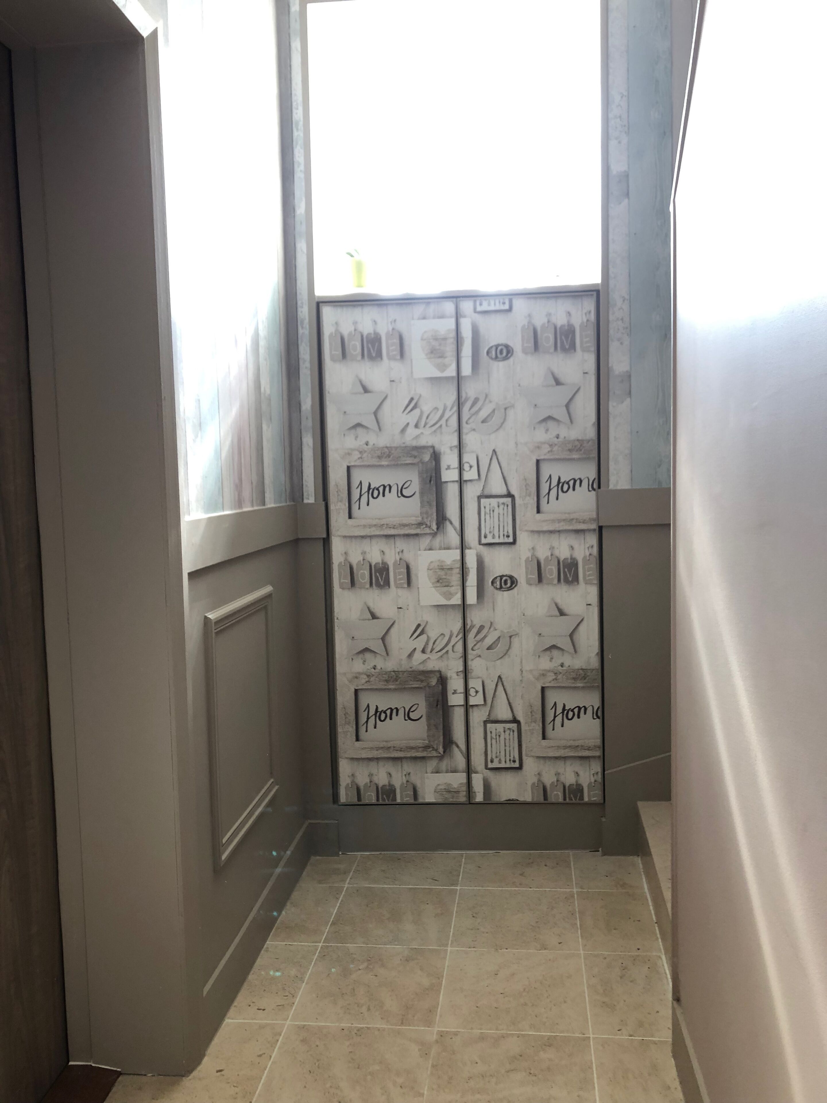 Un pasillo con una puerta que presenta detalles decorativos y la palabra 'Home' repetida a ambos lados.