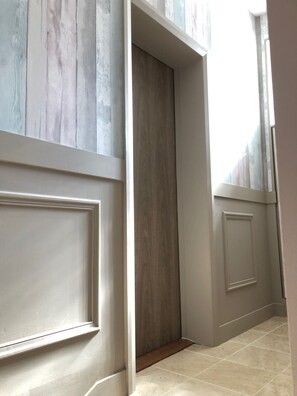 A hallway with a wooden door, a white door, and a tiled floor. - Hyper center, 40 minutes from Paris (Mennecy)