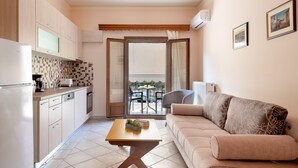 A compact living space with a kitchenette, a dining area, and a sofa. - Katerina's cozy mountain view apartment (Argostoli)