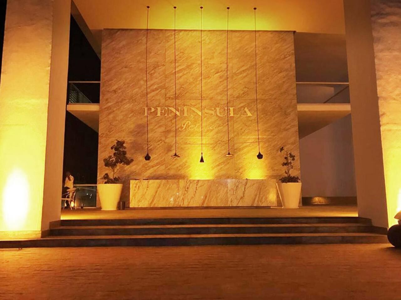 A modern building facade with the name "PENINSULA" prominently displayed.