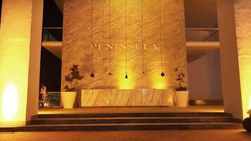 A modern building facade with the name "PENINSULA" prominently displayed.