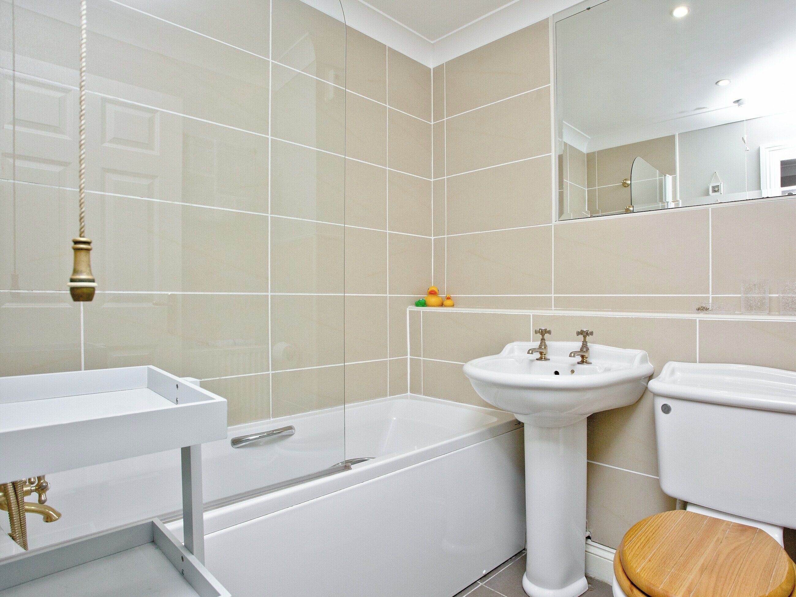 A modern bathroom with a bathtub, sink, and toilet.