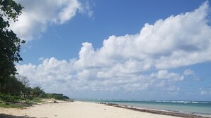 A sandy beach with a clear sky and scattered clouds. - Hideaway  by the Sea (Montego Bay)
