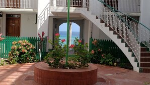 A courtyard with a central planter, a staircase, and a view of the sea. - Hideaway  by the Sea (Montego Bay)