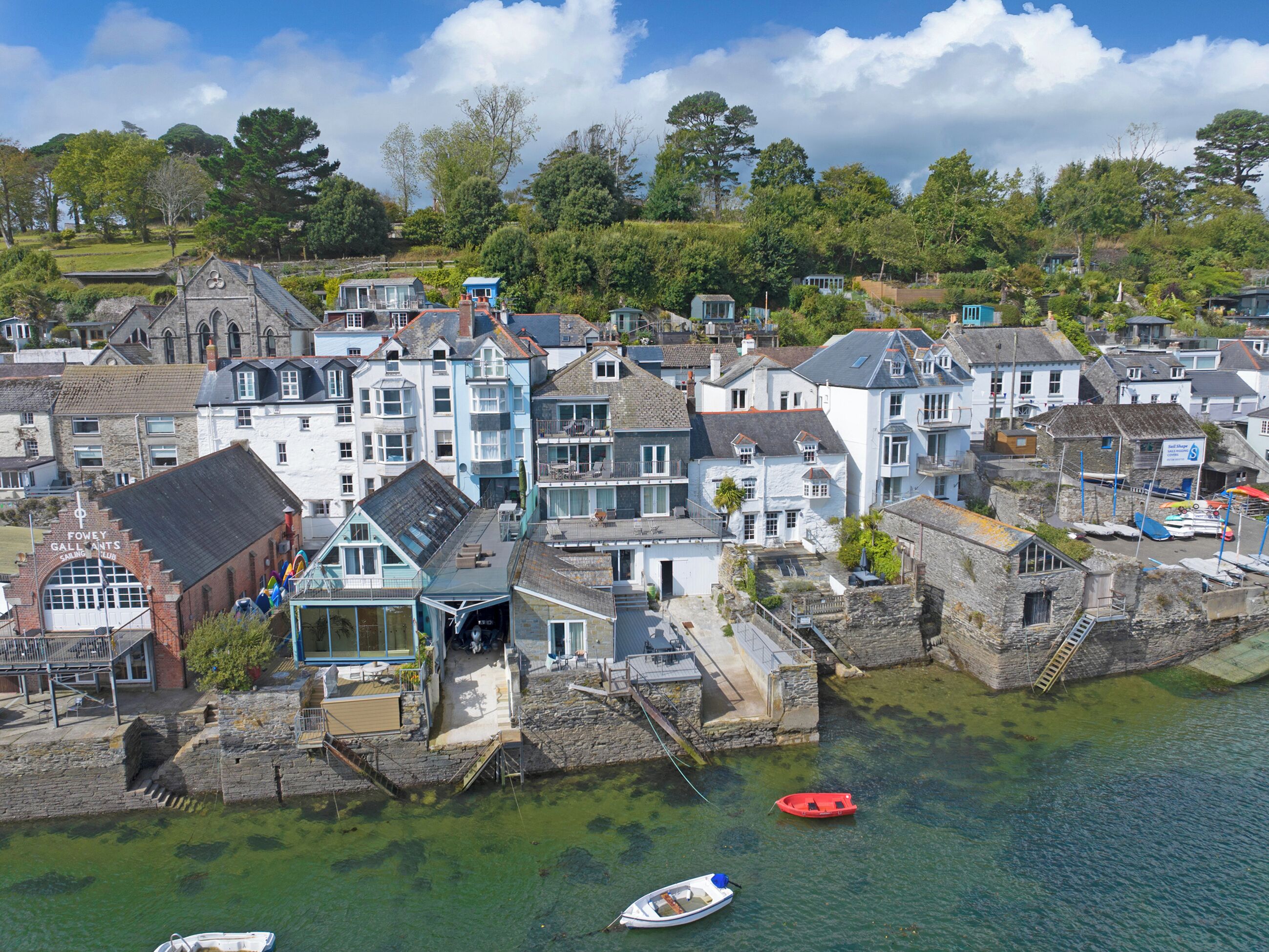 A coastal town with stone buildings, a pier, and boats.