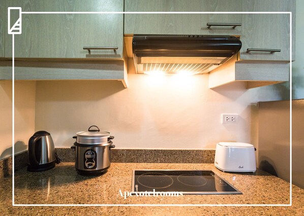 A kitchen with a built-in stove, a kettle, and a toaster on the countertop.